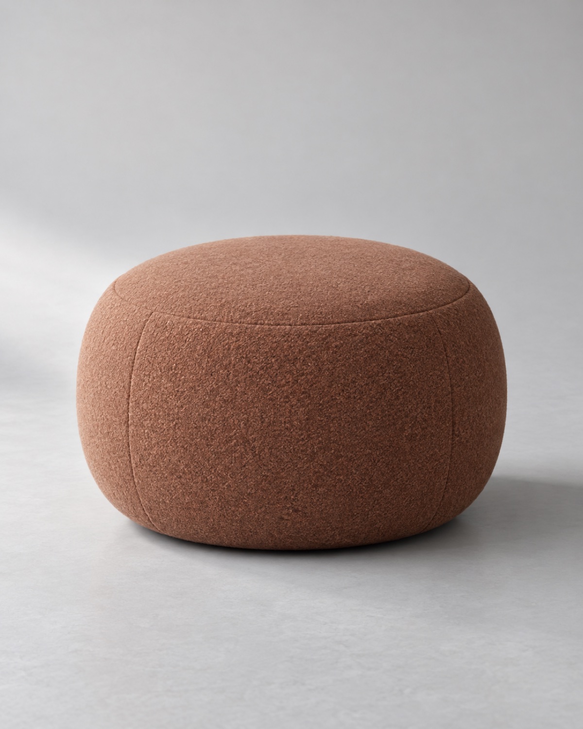 Rounded ottoman upholstered in clay wool blend